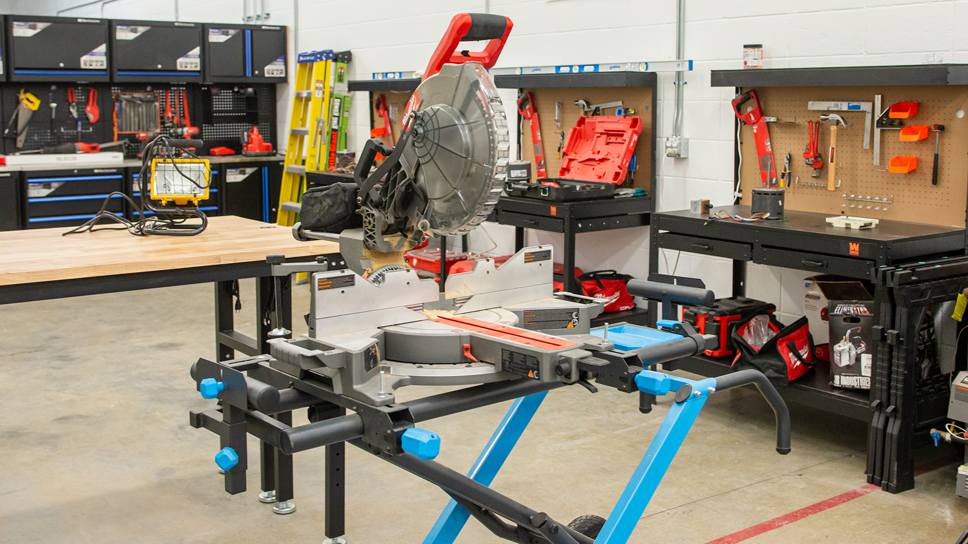 A room full of construction tools with a power saw on a table in the foreground
